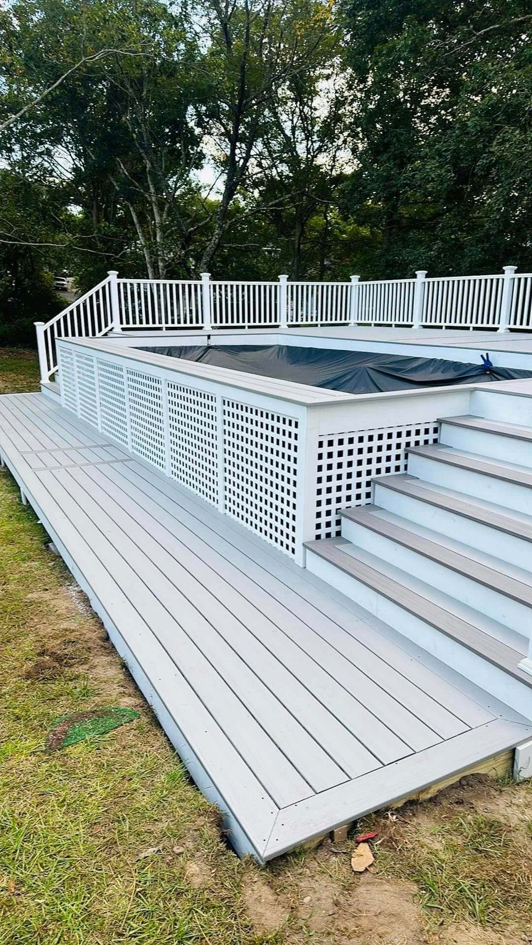 Cape Cod pool deck with lattice skirting by KDM Home Improvement