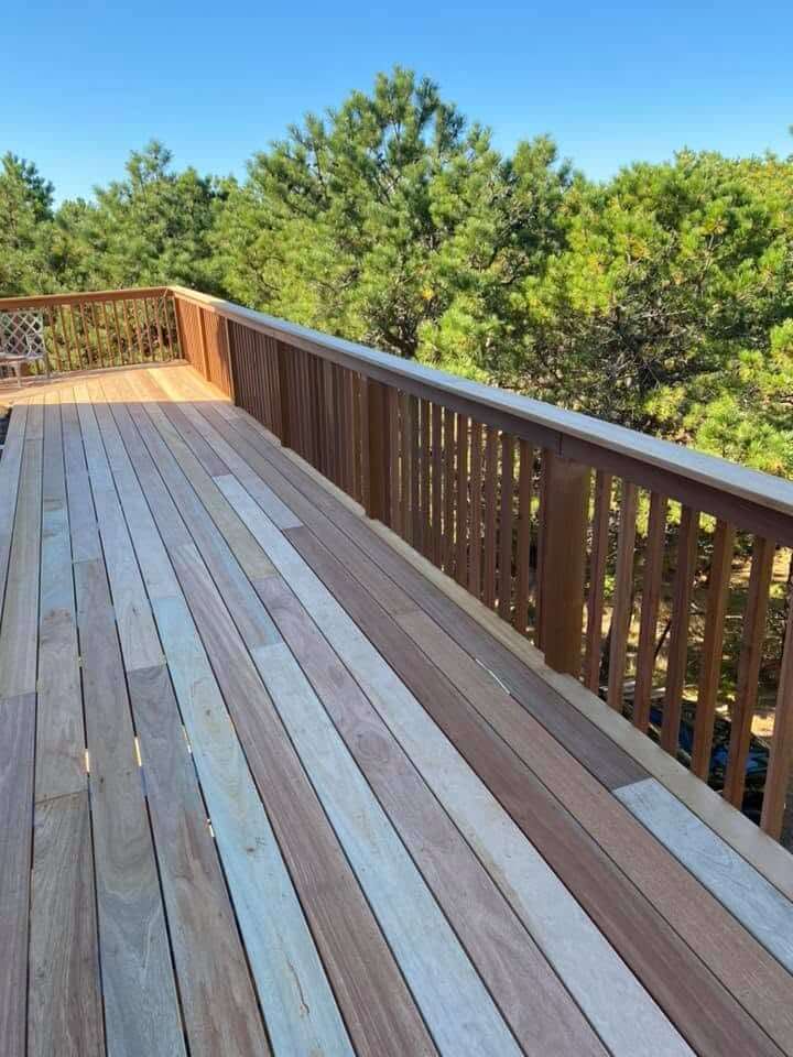 Elevated mahogany deck with treetop views on Cape Cod by KDM Home Improvement